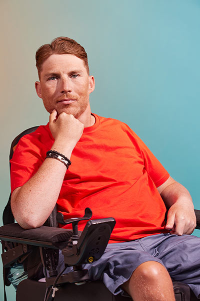 Ein Mann mit braunem Haar und Bart stützt seinen Kopf auf eine Hand und schaut nachdenklich.